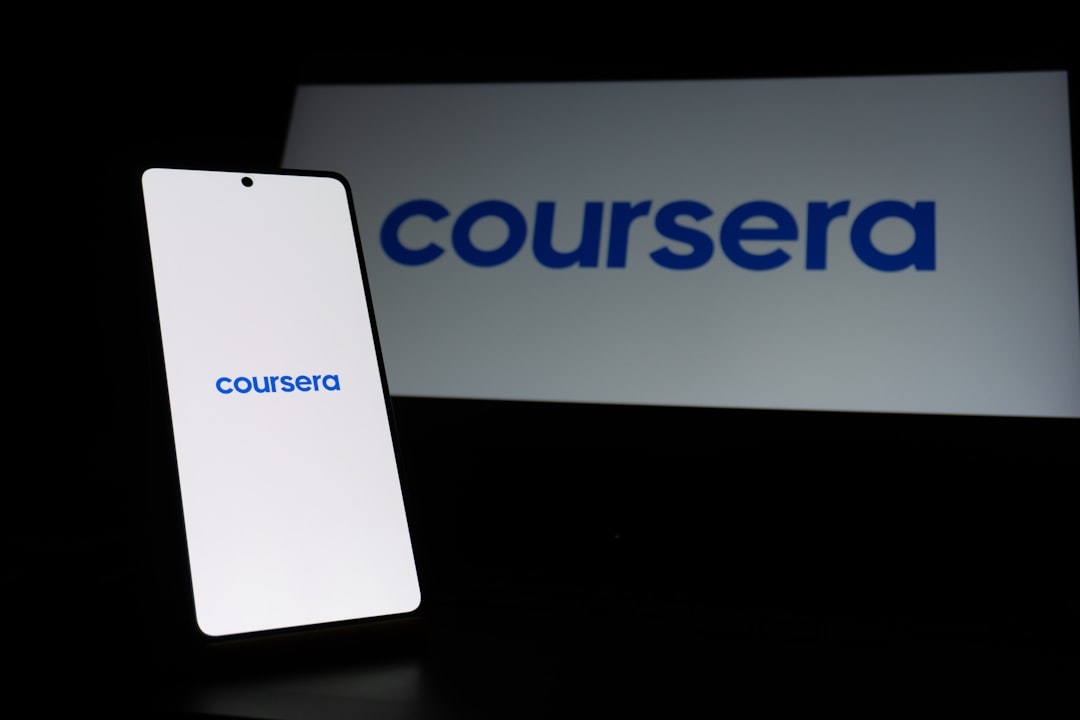 smartphone-displaying-coursera-logo-next-to-large-logo-ojrjokmyr2k